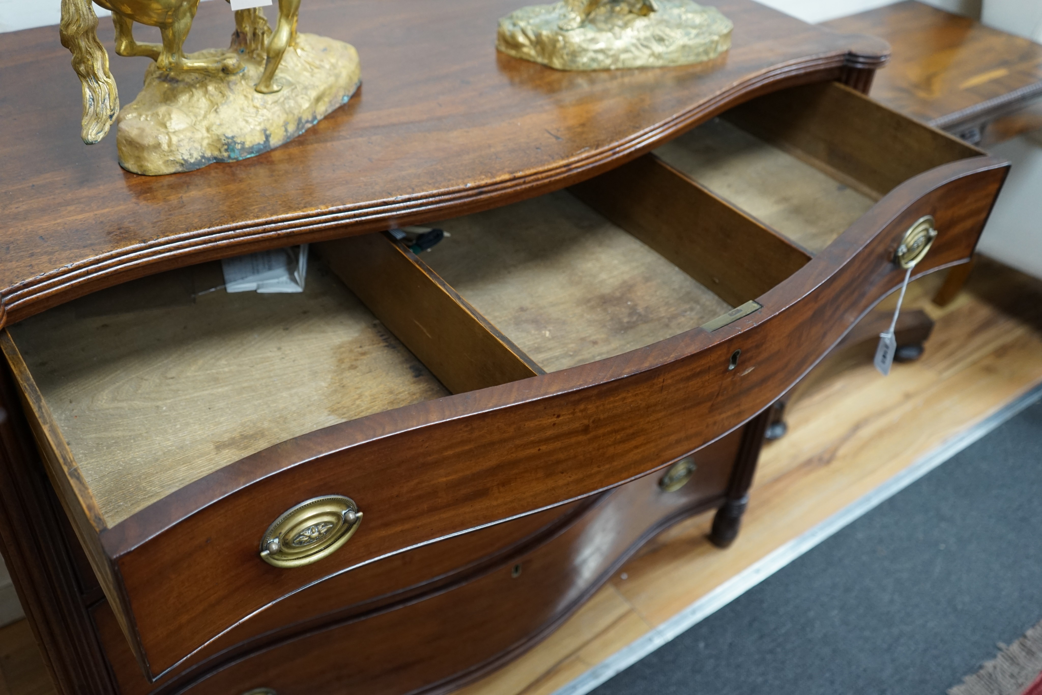A George III mahogany serpentine chest of four long drawers, width 115cm, depth 58cm, height 97cm